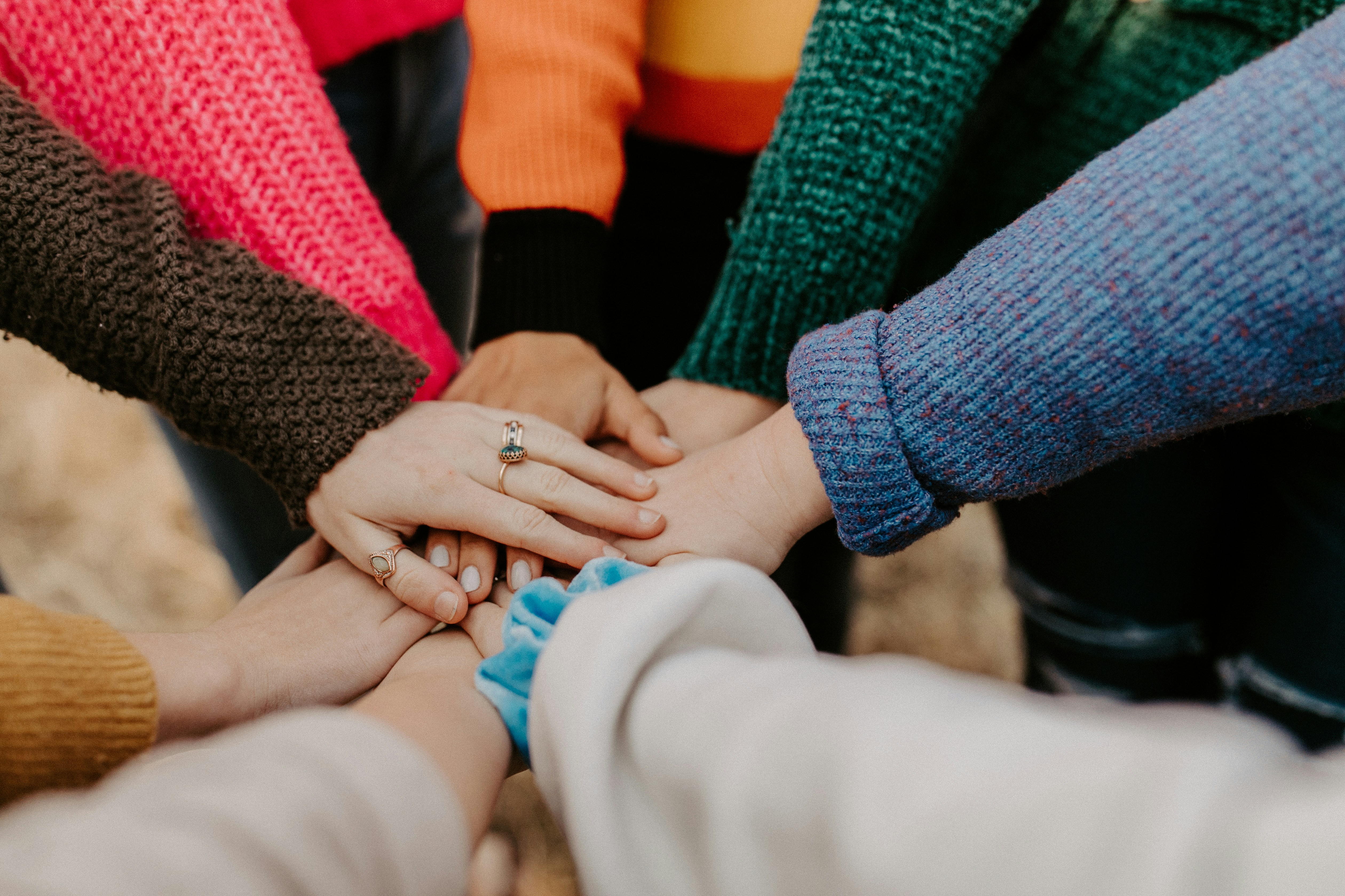 group of people with hands reaching out together in a circle