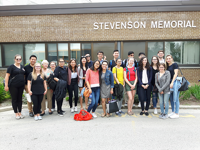 A group of student volunteers and their instructors standing outside of Stevenson Memorial Hospital 