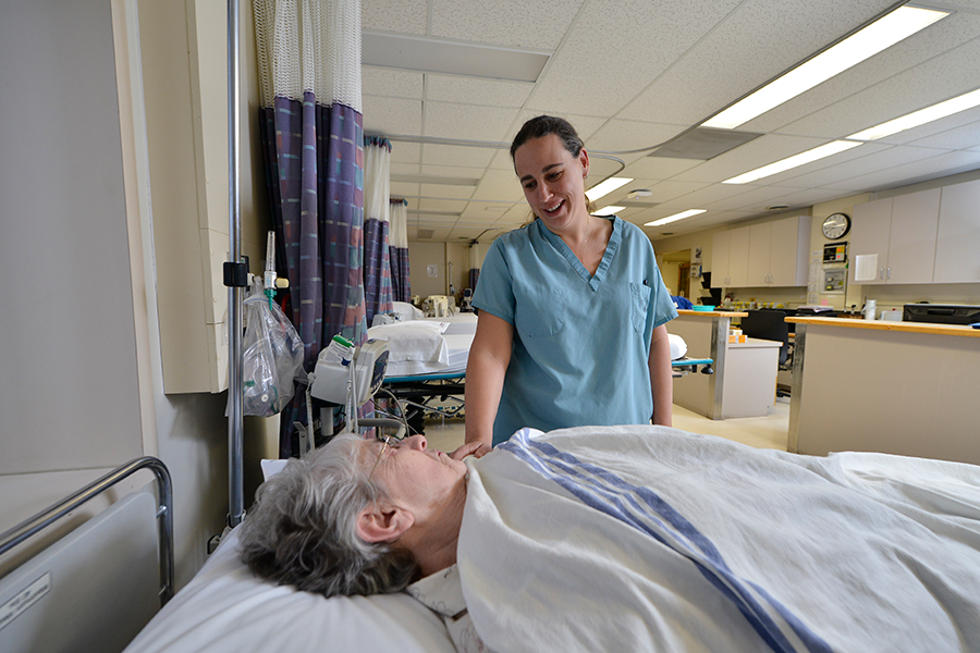 woman in hospital bed being attended to by SMH nurse after surgery 